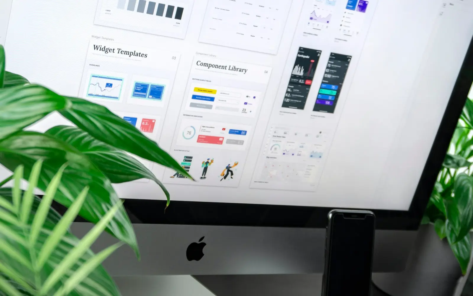 Designer working on UI and UX screens at a desk